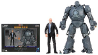 Action figure of a man in a suit next to a large robot figure with packaging in the background.