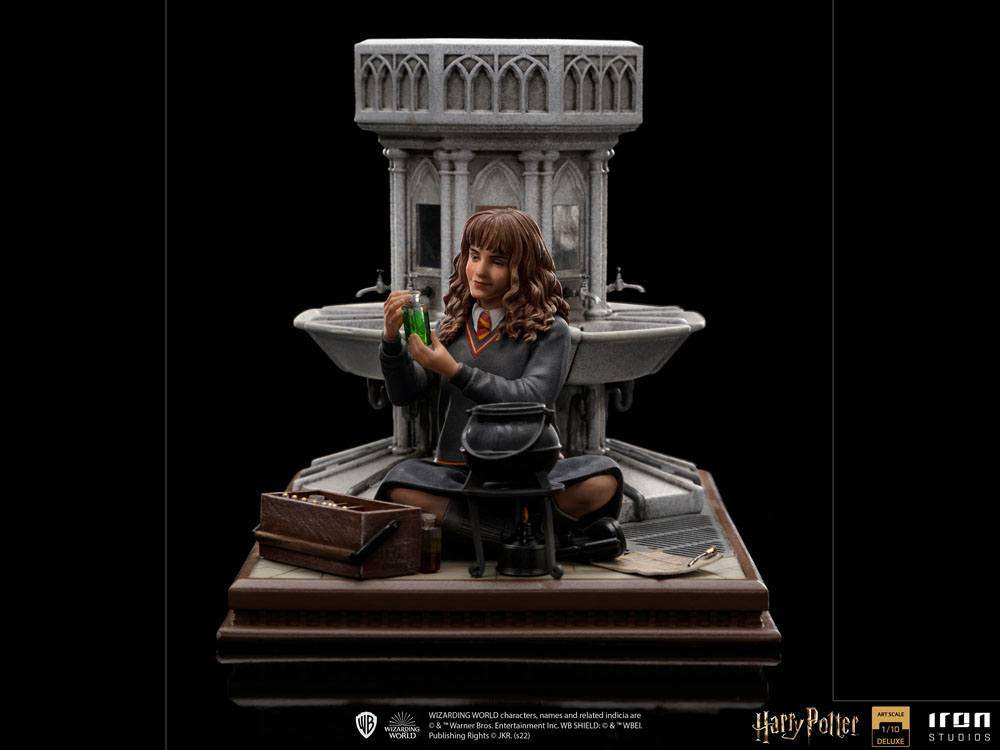 Iron Studios 1/10 Hermione Granger Polyjuice statue sits before a stone fountain with a cauldron and potion vial.
