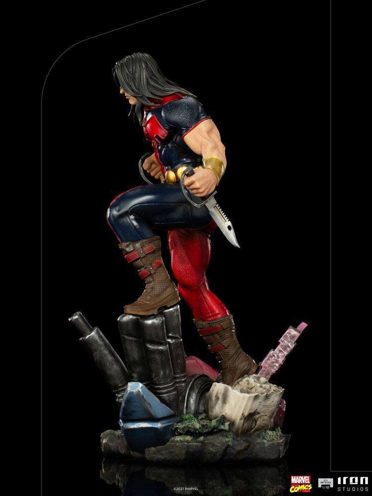 Side view of Iron Studios Warpath 1/10 scale statue featuring the X-Men hero holding knives on a rubble base.