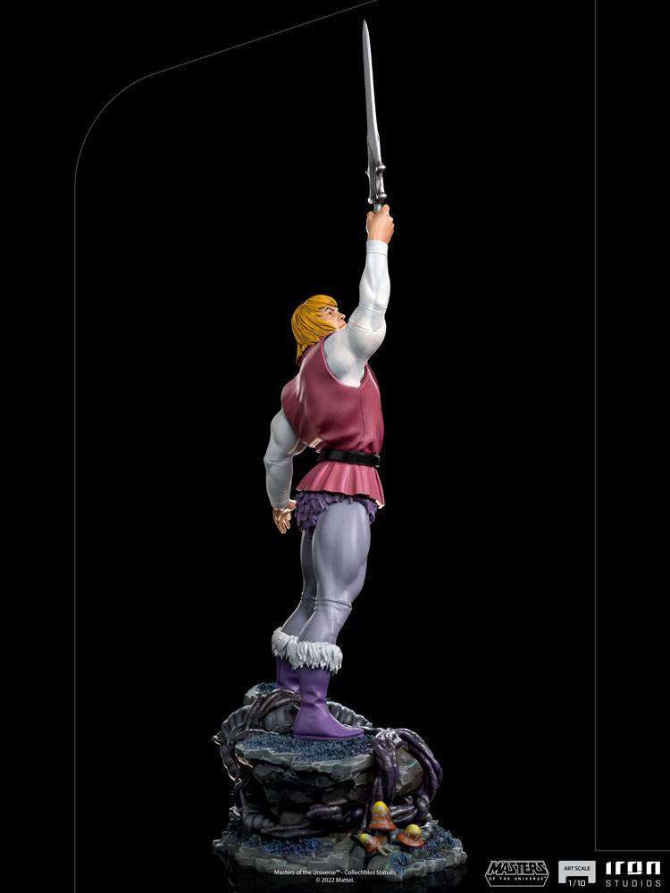 Side view of the 38 cm Iron Studios Prince Adam statue, holding a sword aloft on a detailed rocky base.
