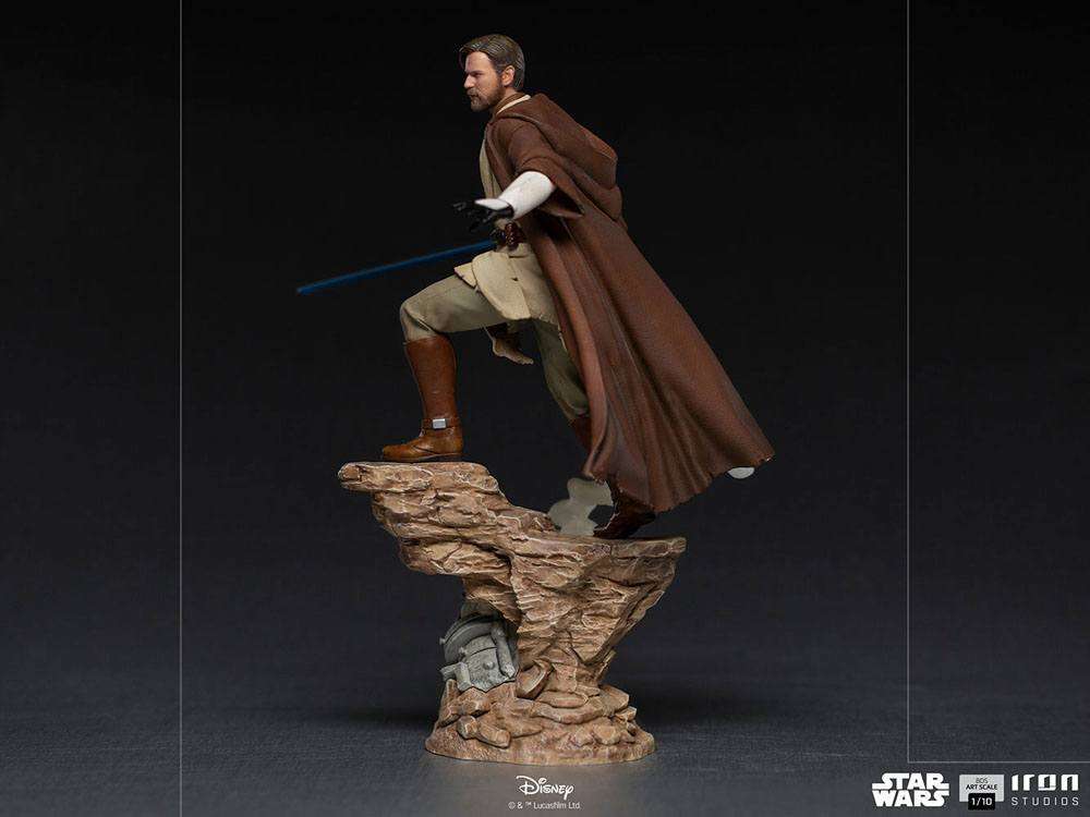 Side view of Iron Studios Obi-Wan Kenobi 1/10 scale statue in brown robes with a blue lightsaber on a rocky base.