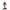 Front view of Iron Studios 1/10 Peacemaker statue in red and tan uniform with a chrome helmet on a rocky base.